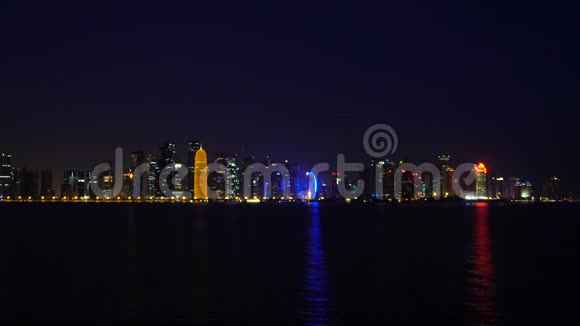 多哈夜城视频景观卡塔尔中东在海湾的海水中反射出西湾的发光摩天大楼视频的预览图