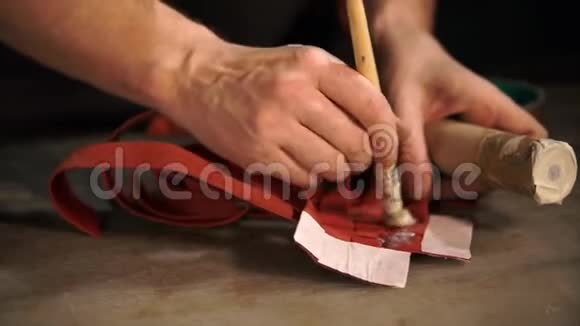 坦纳在皮革交织的带子上涂抹粘合剂特写的手视频的预览图
