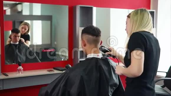 理发师用电动剃须刀理发一个人希望改变形象视频的预览图