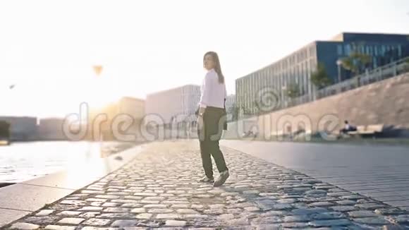 美丽的女孩走在日落的斯普林河边视频的预览图