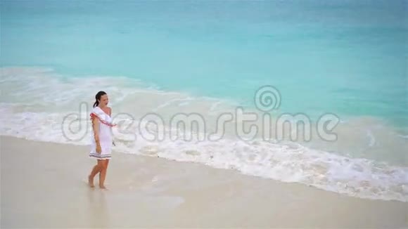 快乐的女孩在浅水中行走白色海滩上一位女士的俯视图视频的预览图