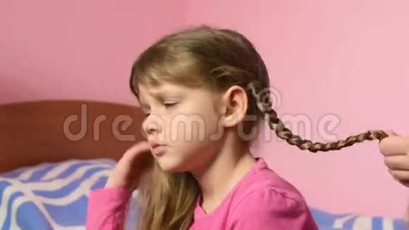 妈妈给女儿扎辫子亲了亲她的脸颊视频的预览图