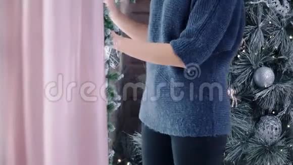 可爱的金发模特在圣诞树附近摆姿势视频的预览图
