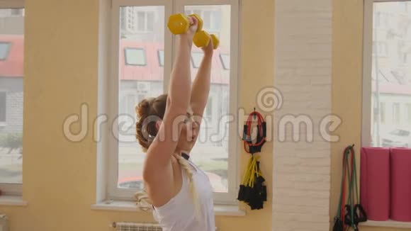 健身运动训练和人的概念快乐的女人用哑铃锻炼视频的预览图