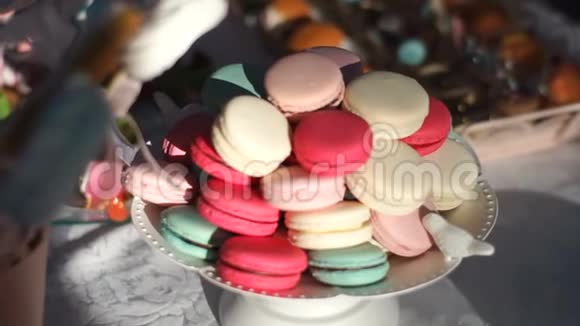 在婚礼桌上放着五颜六色的美味玛卡龙甜点生日仪式视频的预览图