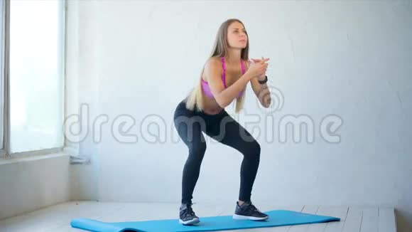 漂亮运动的女人做深蹲以加强健身房的臀部视频的预览图