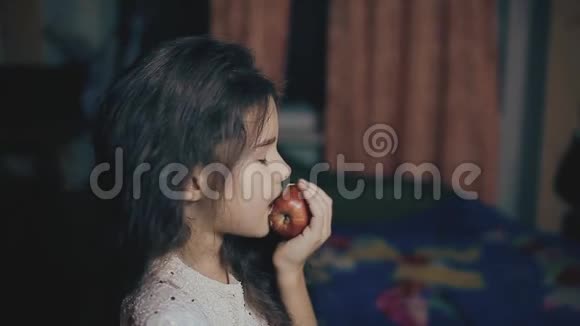 小女孩晚上在室内吃苹果健康食品小女孩生活方式与水果苹果视频的预览图