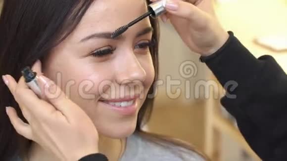 化妆师在画室里画模特的眉毛视频的预览图