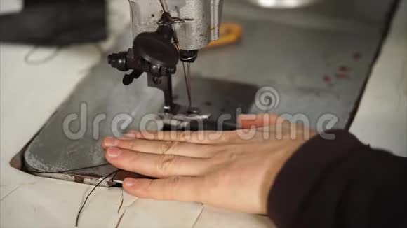 女裁缝正在缝纫机上做皮革配件的生产视频的预览图