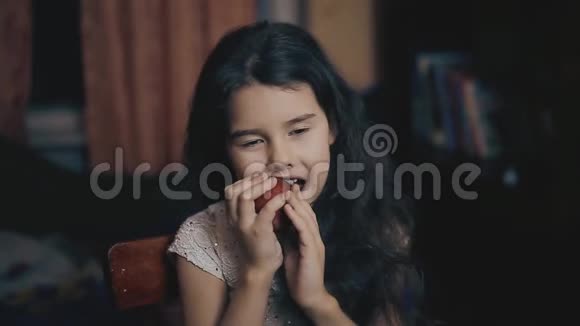 小女孩晚上在房间的室内吃一个苹果健康食品小女孩和水果苹果的生活方式视频的预览图