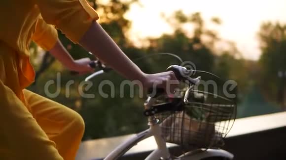 一个面目全非的女人手拿着车把骑着一辆带篮子的城市自行车视频的预览图