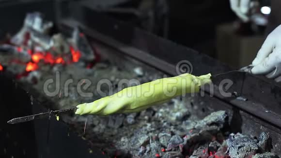 街头小贩在木炭烤架上烹制传统美食视频的预览图