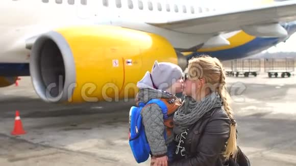妈妈和孩子正站在机场的飞机附近视频的预览图