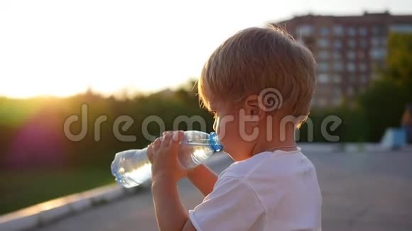 婴儿从户外的瓶子里喝水日落时间视频的预览图
