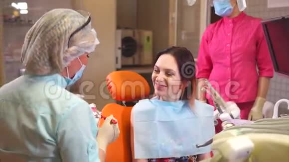 女牙医向病人展示如何刷牙她用人类的嘴视频的预览图