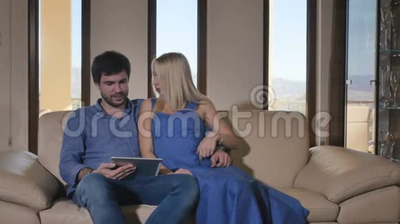 漂亮的一对夫妇在沙发上放松笑着视频的预览图