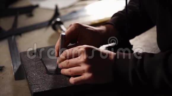 斯金纳正在用一个黑色的皮制成的皮包在空白的地方打小洞视频的预览图