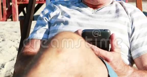 老人在日光浴室放松时在手机上聊天视频的预览图