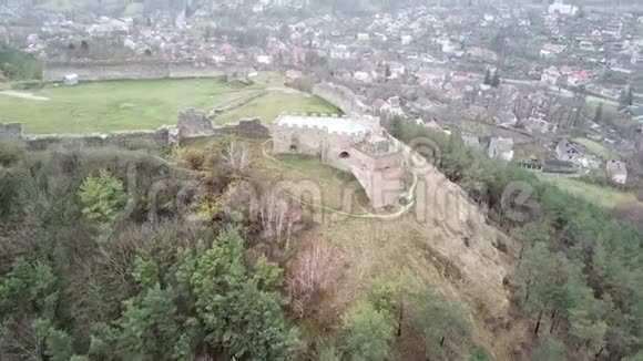 对古中世纪古堡遗址的空中勘测该遗址位于一座树木茂密的山顶上并位于下层视频的预览图
