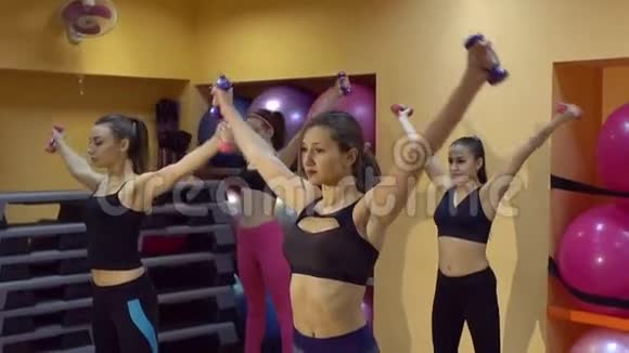 健身俱乐部的年轻女性用哑铃做运动慢动作视频的预览图