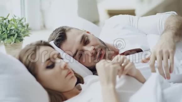 亲密关系有问题的夫妻在家里躺在床上进行情感对话视频的预览图