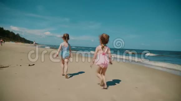 夏天两个小女孩在海滩上奔跑视频的预览图