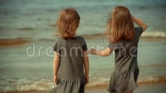 夏天两个女孩站在沙滩上的水里视频的预览图