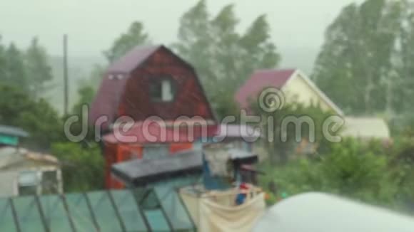 雨天的场景聚焦雨落在天空模糊的房子背景视频的预览图