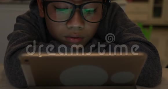 把戴眼镜和使用平板电脑的可爱的亚洲男孩关起来视频的预览图