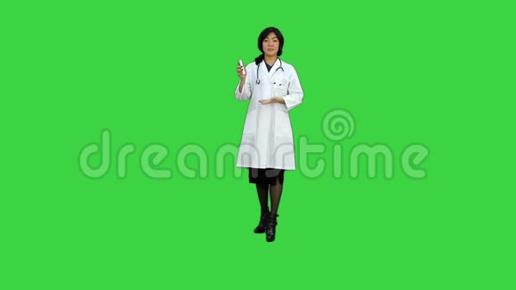 亚洲女医生把药盒放在绿色屏幕上Chroma键视频的预览图