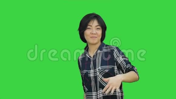 美丽的年轻商务女性庆祝成功跳舞看着绿色屏幕上的相机Chroma键视频的预览图