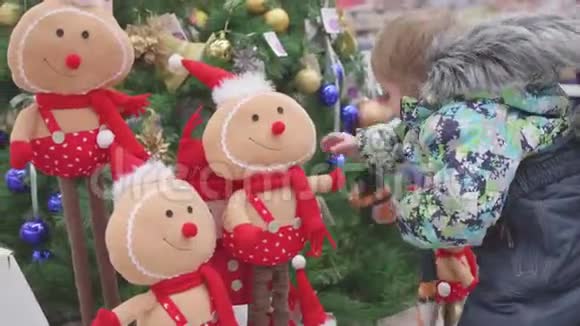 父子俩在商店里选一棵圣诞树在圣诞节前出售玩具和圣诞树视频的预览图