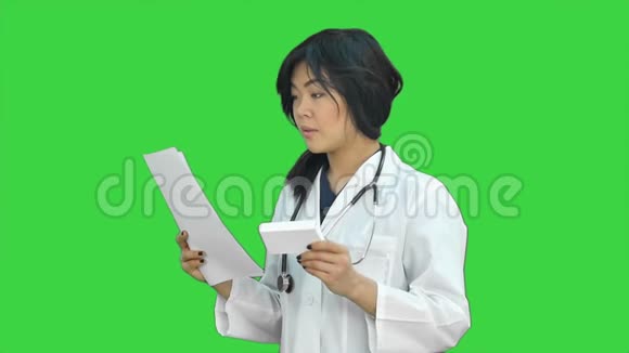 女医生举着一盒药片微笑着把它呈现在绿色屏幕上Chroma键视频的预览图