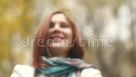 快乐的女人在秋天慢悠悠地扔树叶微笑着视频的预览图
