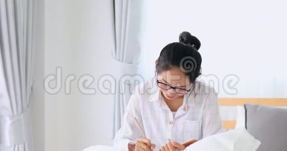 亚洲美女在卧室的床上写作视频的预览图