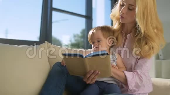 可爱的女人在家给孩子读书视频的预览图