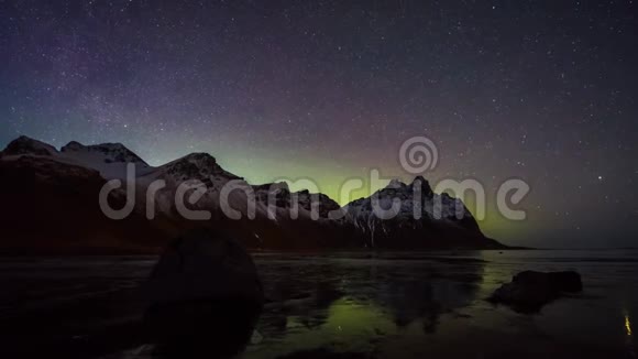 在暗极夜的夜空中用明亮的霓虹灯绿色紫色北极光北极光在4k的时间流逝中拍摄星星视频的预览图