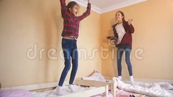 两个快乐的姐妹在卧室床上跳跃的慢动作视频视频的预览图