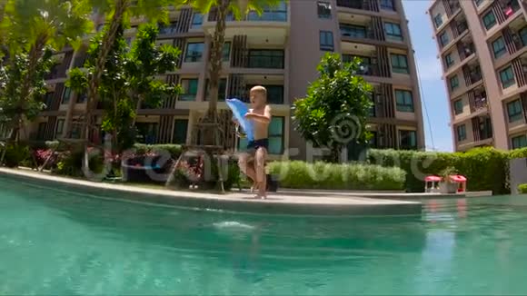 小男孩跳进游泳池的慢镜头视频的预览图