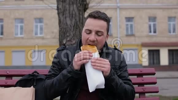 在城市里人们坐在长凳上吃热狗视频的预览图