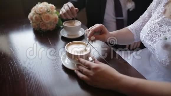 年轻夫妇在咖啡馆吃早餐时聊天喝咖啡他们把糖混在卡布奇诺里视频的预览图