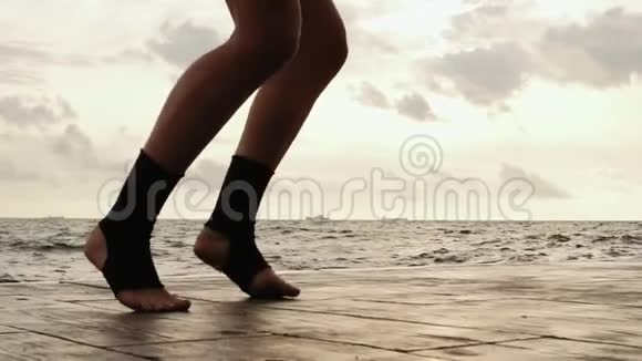 女拳击手在训练中腿向前移动女人在海滩边训练双腿特写慢镜头视频的预览图