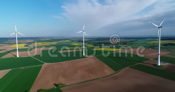 从绿色农田飞到远处的风力发电机视频的预览图
