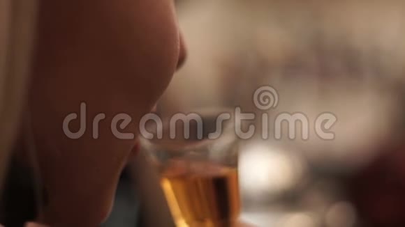 女孩在酒吧里喝一小杯威士忌金发女孩在酒吧品尝白兰地视频的预览图