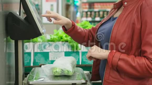 超市里买蔬菜的女人黄瓜和西红柿在秤上称重自助服务4k视频的预览图