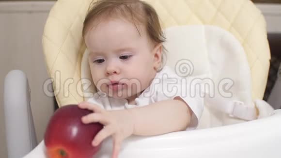 小孩子在桌子上玩红苹果视频的预览图