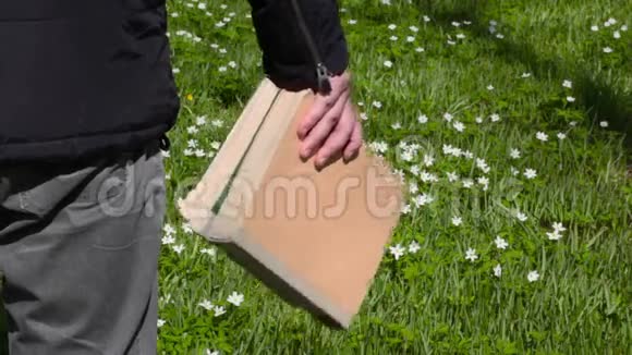 带着绿色草地上的书的人视频的预览图