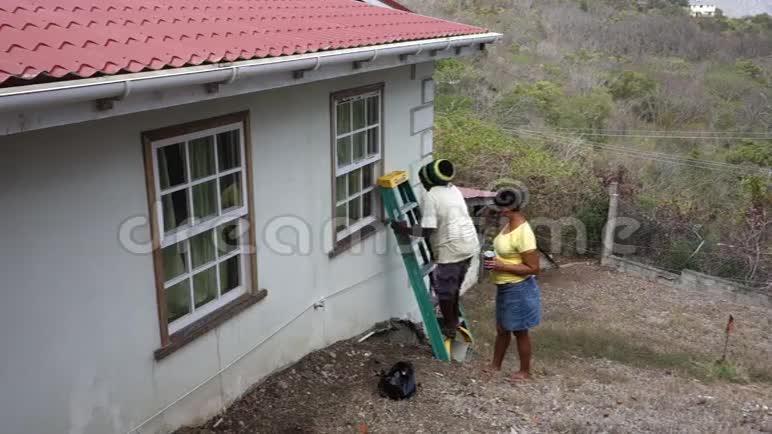 在热带地区维修房屋的工人视频的预览图