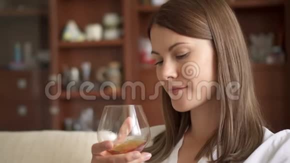慢动作的女人在家享受舒适的夜晚独自喝着白兰地白兰地白兰地视频的预览图