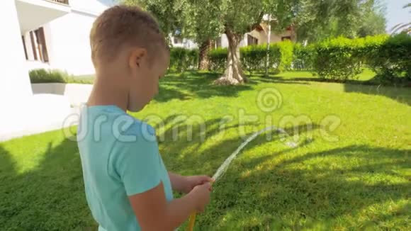 玩耍的孩子在房子旁边浇绿草坪视频的预览图
